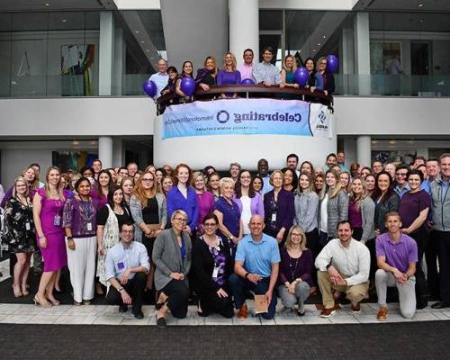 Large group of people wearing purple gather for photo after 澳门足彩app Women's Network event